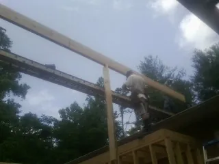 Carpenter setting a ridge beam over a new addition frame — Ice Dam Removal by Roofing Brothers in Delray Beach
