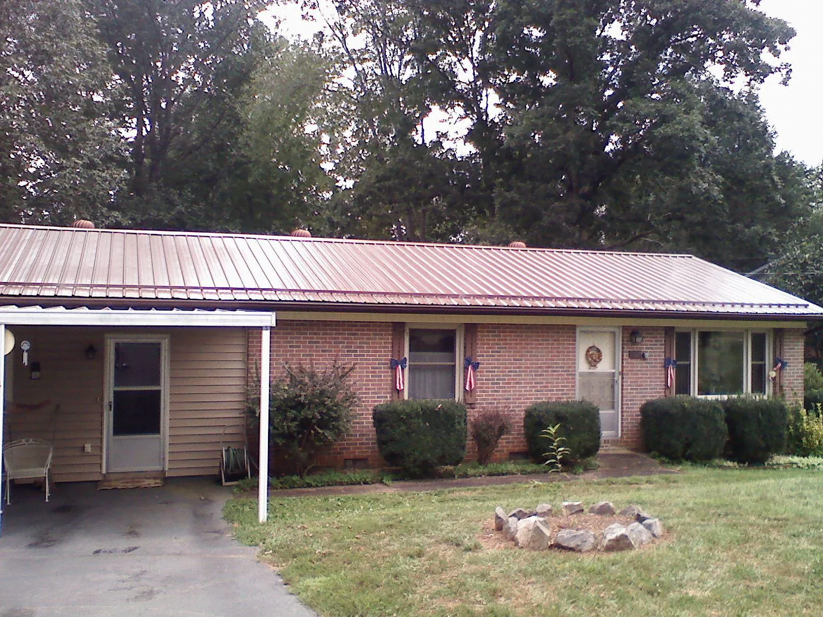 Bronze metal roof and carport on a brick ranch home — Roof Repair work by our crew in Delray Beach