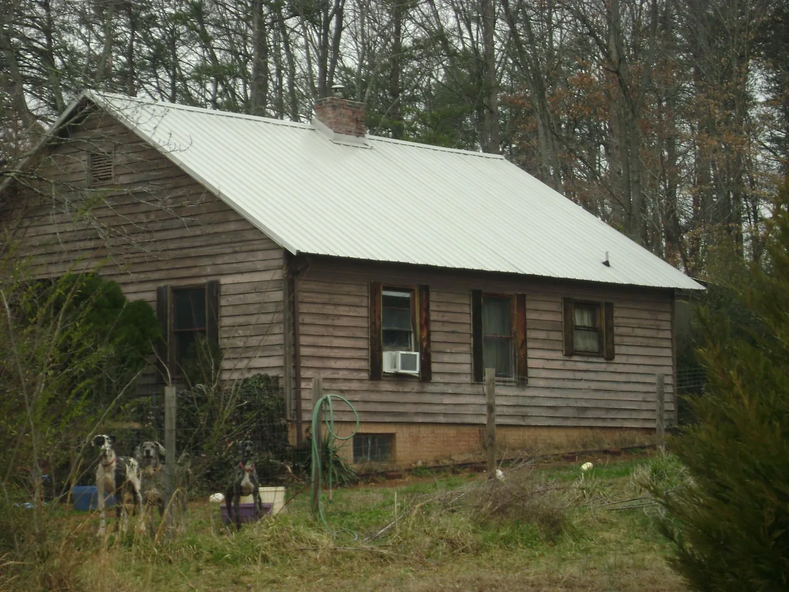 White metal roof on an old wood sided farmhouse, from a Metal Roof Installation job in Delray Beach